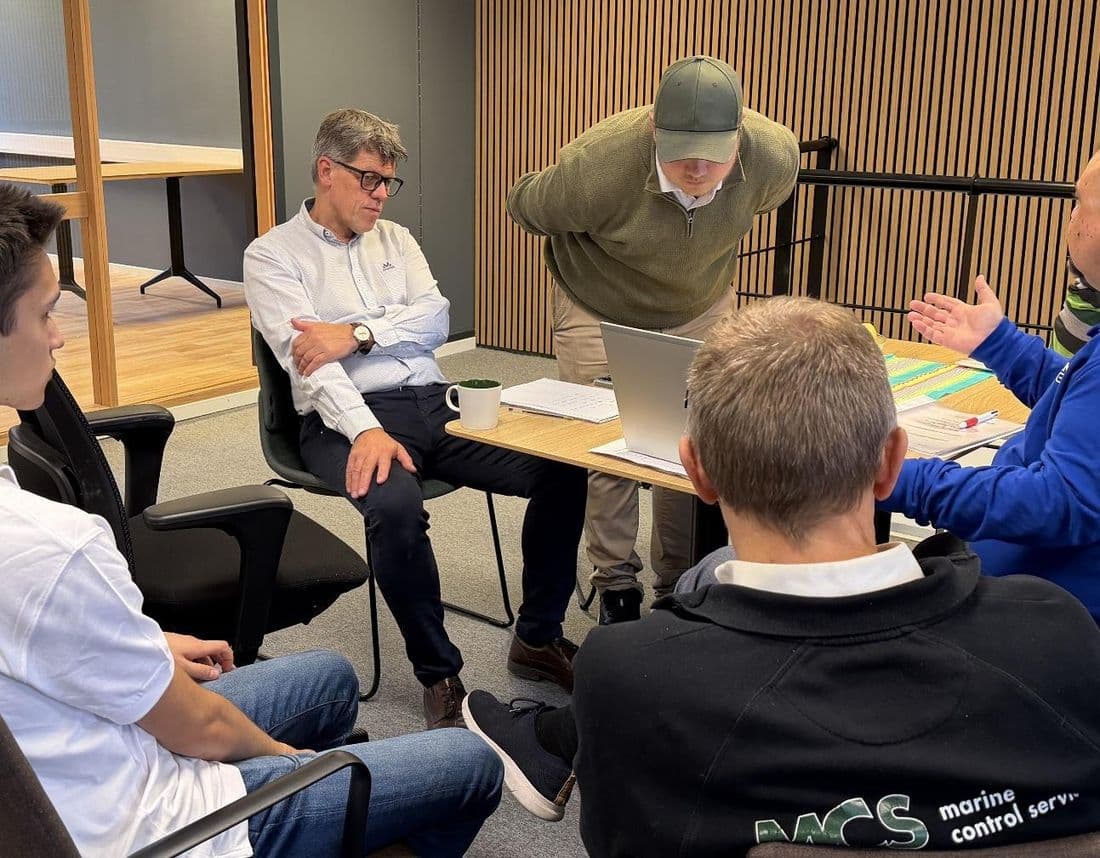 The MCS team around a table at the office in Drammen